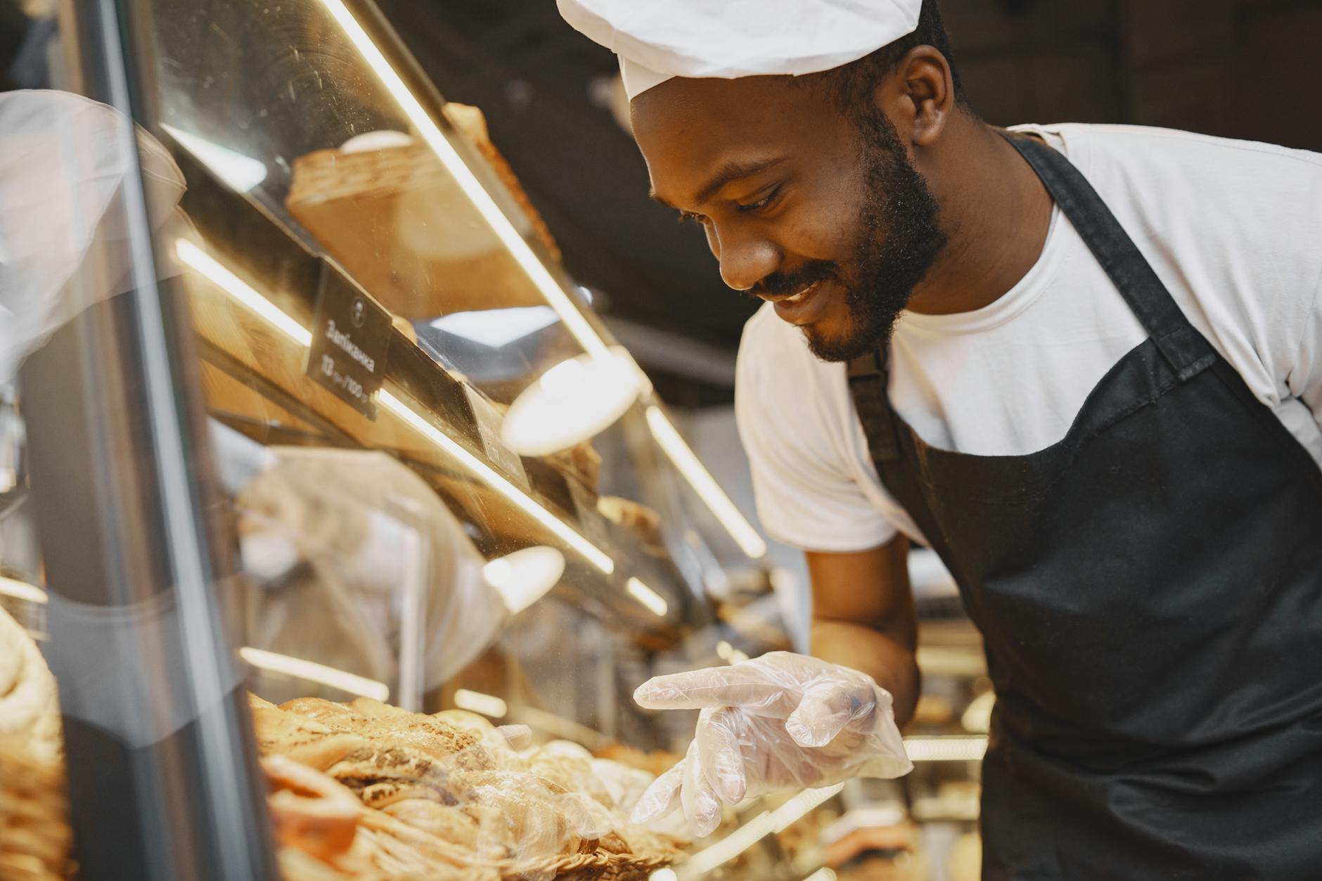 Pastry chef pointing at baked goods on display
